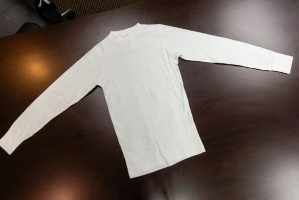 White long-sleeved shirt on table.