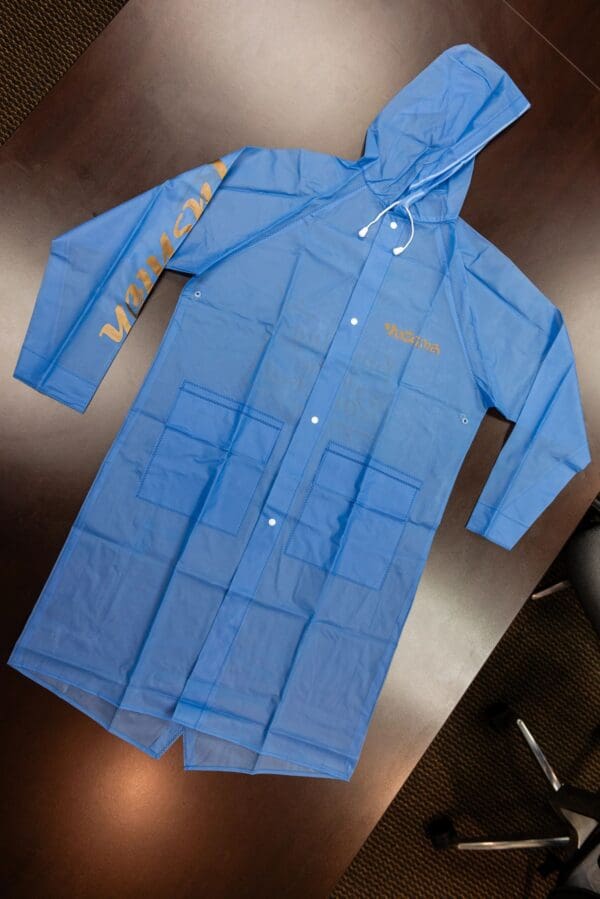 Blue hooded raincoat with pockets and logo.