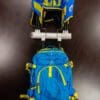 A blue and yellow backpack is on the back of a cart.