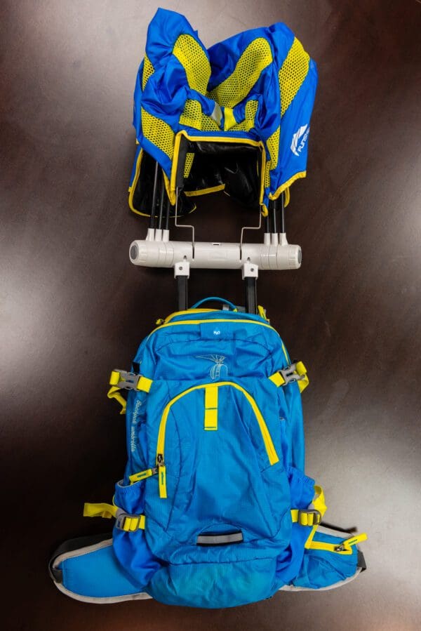 A blue and yellow backpack is on the back of a cart.