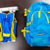 A blue backpack and vest sitting on top of a table.