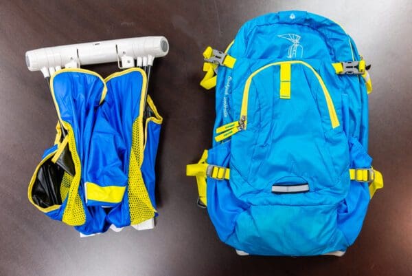 A blue backpack and vest sitting on top of a table.