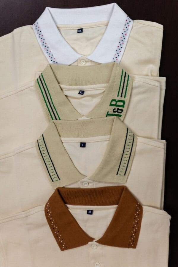 Four white polo shirts with different collars.